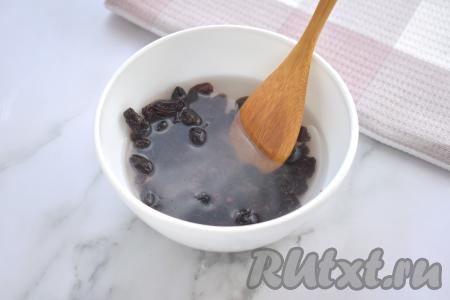 Достаём покупное слоёное тесто из морозилки (я купила дрожжевое слоёное тесто, но можно взять и бездрожжевое). Пока тесто размораживается, можно заняться изюмом. Промываем изюм проточной водой, выкладываем в миску, заливаем полностью кипятком, оставляем на 5-7 минут. Затем распарившийся изюм откидываем на сито, промываем проточной водой. Раскладываем изюм на бумажном (или тканевом) полотенце, даём обсохнуть. Осматриваем изюм, если есть остатки веточек, их нужно будет отделить от изюма.