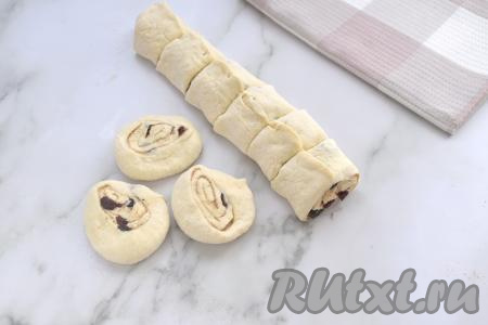 Конец рулета закрепляем.&nbsp;Нарезаем получившийся рулет из слоёного теста с изюмом на кусочки шириной примерно 3,5 сантиметров. У меня получились 9 кусочков. Кусочки теста ставим на срезы и сверху прижимаем слегка ладонью.