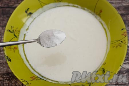 Пока изюм запаривается, можно заняться тестом для шоколадных куличей. Для этого нужно подогреть кефир до комнатной температуры. В тарелку с кефиром комнатной температуры всыпать соду, хорошо перемешать ложкой и оставить на время, пока будем заниматься взбиванием масла. Я подогреваю кефир до комнатной температуры в микроволновке на максимальной мощности, для этого вливаю кефир в глубокую тарелку, ставлю в микроволновку, прогреваю 20 секунд, достаю, перемешиваю, если кефир недостаточно подогрелся, ставлю в микроволновку ещё на 10-20 секунд. Микроволновка греет неравномерно, поэтому после каждого 20 секундного подогрева, обязательно нужно перемешивать кефир. За 30-40 секунд кефир будет уже комнатной температуры. Нам нужно, чтобы кефир подогрелся, но не свернулся.