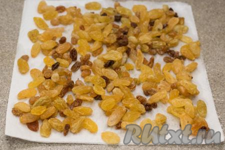 Затем откинуть распарившийся изюм на сито, промыть водой. Дать лишней воде с изюма стечь. После этого разложить его на бумажном полотенце, чтобы он обсох. В процессе обсыхания изюма осмотреть его, если на изюминках есть остатки веточек, их нужно будет убрать.