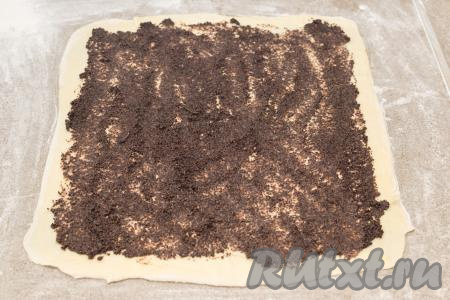 Затем при помощи чайной ложки распределить по тесту половину маковой начинки, отступив от краёв теста примерно 1,5-2 сантиметра.