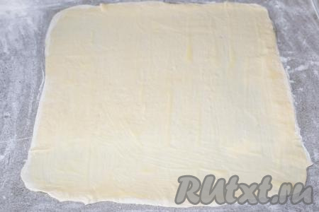 Раскатанный пласт слоёного теста с помощью&nbsp;кулинарной кисти полностью смазать половиной растопленного масла. Оставшееся масло будем использовать для смазывания второго пласта теста в процессе формирования второго кулича.