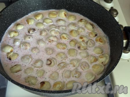 Получившийся соус из сметаны влить в сковороду с обжаренными пельменями. Соус должен практически полностью покрывать пельмени. Если необходимо, добавьте ещё немного воды в сковороду, не забывая подсолить соус по вкусу.