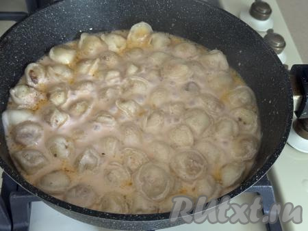 Довести соус из сметаны до кипения, убавить огонь до минимума и томить пельмени под крышкой 10 минут. В течение этого времени 2-3 раза пельмени нужно будет перемешать, чтобы они равномерно приготовились со всех сторон.&nbsp;