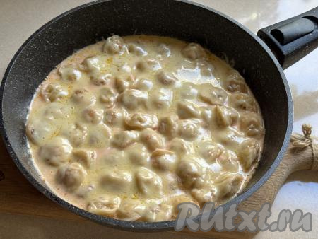 Накрыть сковороду крышкой и снять с огня. Оставить пельмени под крышкой на 4-5 минут (до полного расплавления сыра).&nbsp;