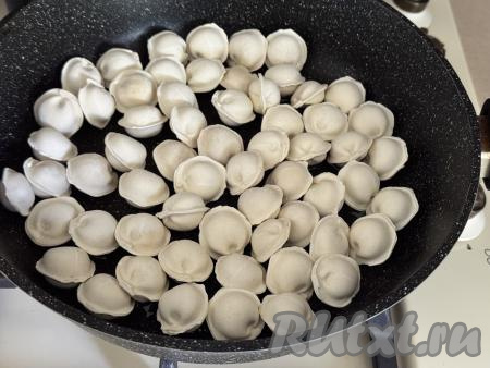 Взять достаточно большую сковороду, разогреть растительное масло, выложить замороженные пельмени (я взяла мини-пельмени) в один слой.&nbsp;