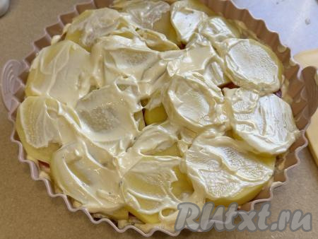 Равномерно поверх помидоров разложить оставшуюся картошку, немного поперчить, смазать сверху майонезом, покрывая весь картофель.