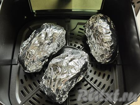 Завернуть каждую картошину в отдельный кусок фольги, выложить заготовки на решётку в чашу аэрогриля.