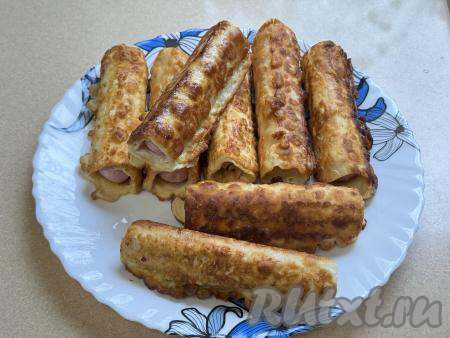 Готовые сосиски в лаваше перекладывать на тарелку и сразу жарить следующую партию.