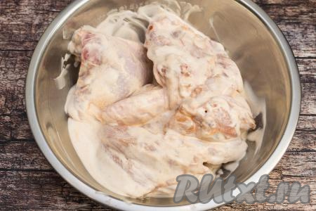 В миску с частями курицы выложить греческий йогурт. Хорошо перемешать, покрывая мясо йогуртом со всех сторон, и оставить мариноваться на 15-20 минут.