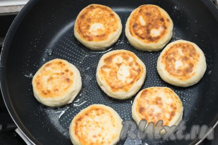 Сырники обжаренные снизу, перевернуть, сделать огонь чуть ниже среднего. Жарить сырники до румяности с другой стороны (примерно 3 минуты). Если после переворачивания сырников масла на сковороде осталось мало, тогда обязательно добавьте немного масла, чтобы сырники хорошо подрумянились и с другой стороны. Когда сырники подрумянятся и со второй стороны, их ещё раз нужно перевернуть, затем накрыть сковороду крышкой, выключить огонь. Дать сырникам потомиться под крышкой без огня в течение 5 минут.