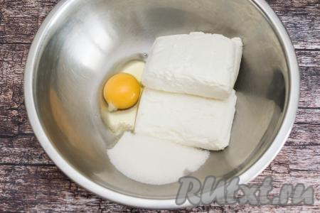 В глубокую миску выложить творог и сырое яйцо, всыпать сахар.