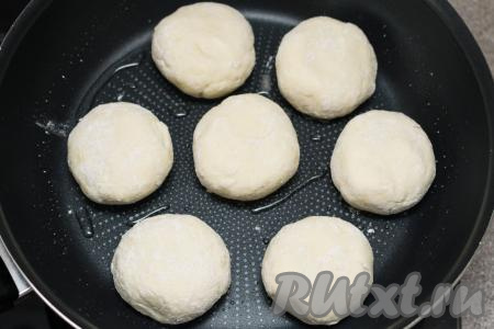 Сковороду хорошо разогреть с добавлением растительного масла. Выложить на сковороду сырники, жарить их на среднем огне в течение 2 минут (до подрумянивания снизу). Сырники при жарке очень любят растительное масло, поэтому его можно не жалеть. Именно жарка на масле придаёт сырникам аппетитную, румяную корочку. У меня сковорода с антипригарным покрытием, для жарки сырников я вливаю примерно 2 столовых ложки масла - этого вполне достаточно, чтобы сырники стали румяными. Если у вас обычная сковородка, тогда вливайте 3-4 столовых ложки масла, а затем готовые сырники, чтоб убрать излишки масла, нужно будет промокнуть бумажными салфетками.