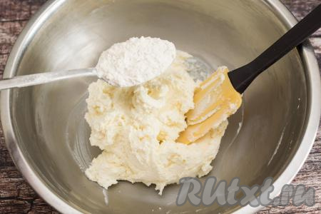 Отмерить муку в отдельную тарелку. Начать добавлять муку в тесто по столовой ложке, сразу вмешивая её лопаткой. Я муку предварительно не просеиваю, так как сырники - это не выпечка.