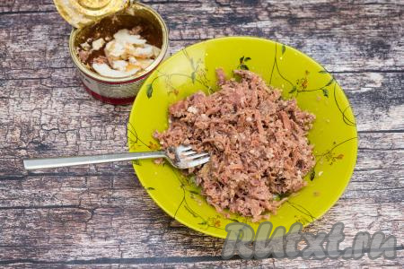 Пока обжариваются овощи, открыть банку с тушёнкой.&nbsp;Переложить тушёнку без жира на тарелку. Жир, оставшийся в банке, нам не понадобится. Вилкой размять тушёнку в тарелке.