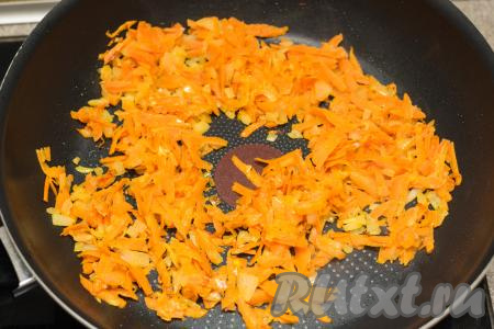 К луку, обжаренному до мягкости, добавить натёртую на крупной тёрке морковь, перемешать овощи. Обжарить в течение 5-6 минут (до мягкости моркови), иногда перемешивая.