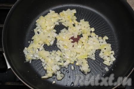 Очистить морковку и лук. Лук мелко нарезать. Прогреть растительное масло в сковороде, выложить нарезанный лук. На среднем огне обжарить лук до мягкости (ориентировочно в течение 3 минут), периодически перемешивая.