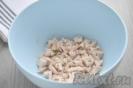 Прежде всего отвариваем куриное филе в течение 25-30 минут с момента закипания подсоленной воды. Варёному мясу курицы даём остыть, нарезаем на маленькие кусочки, выкладываем в миску.