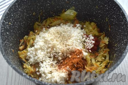 Рис хорошо промываем под проточной водой, лишней воде даём стечь. По прошествии 10-12 минут с начала обжаривания капусты добавляем подготовленный рис, томатную пасту, соль и специи по вкусу (в качестве специй я добавила паприку и чёрный молотый перец).