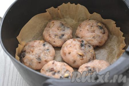 Из куриного фарша с грибами лепим круглые или овальные котлеты одинакового размера (я сформировала 6 штук). Для того чтобы фарш не прилипал к рукам в процессе формирования котлет, можно руки периодически смачивать водой. Чашу аэрогриля застилаем пергаментом. Смазываем пергамент немного растительным маслом. Выкладываем в застеленную чашу котлеты из куриного фарша с грибами в один слой. Отправляем чашу в аэрогриль.