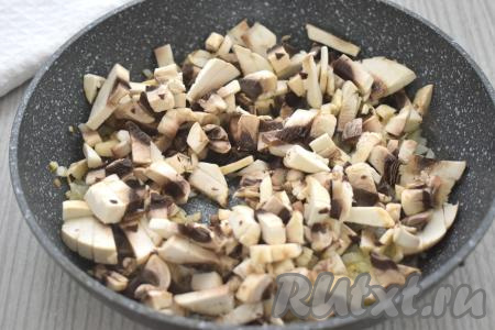К обжаренному луку добавляем шампиньоны, нарезанные на небольшие кубики, перемешиваем и обжариваем 6-7 минут (до полного испарения влаги из грибов), время от времени перемешивая. Жареные грибы с луком убираем с огня, даём остыть.