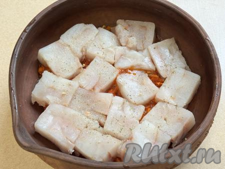 Размороженное филе минтая нарезать на кусочки, посолить, поперчить, выложить в форму для запекания поверх овощей.