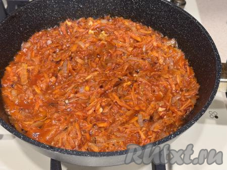 Перемешать овощи, равномерно распределяя томатную пасту по морковке и луку, влить 50 миллилитров воды, перемешать. Довести до кипения, протушить 5 минут на небольшом огне, снять с огня. Морковке с луком, протушившимся в томатном соусе, дать немного остыть.