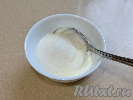 Для приготовления начинки соединить в глубокой миске сметану и сахар, перемешать столовой ложкой до однородности.