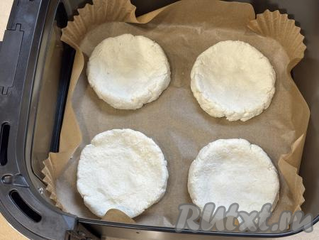 Дно чаши аэрогриля застелить пергаментом. Сформировать руками из каждой части творожного теста круглую ватрушку с бортиком. 4 сформированных заготовки ватрушек выложить в чашу аэрогриля.