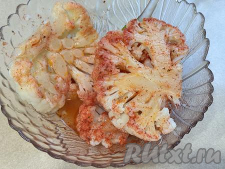 Стейки из цветной капусты со всех сторон смазать смесью масла и специй. Для этого я выложила стейки в миску со смесью масла и специй, затем обмазала их со всех сторон. Для того чтобы стейки пропитались смесью масла и специй, дать полежать им при комнатной температуре в течение 10-15 минут.