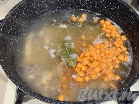 В закипевший бульон выложить нарезанные морковку, картошку и куриное мясо, я решила добавить ещё 1 лавровый лист. Дать супу закипеть, уменьшить огонь, варить на небольшом огне 20 минут (до готовности моркови и картошки, овощи должны стать мягкими, легко прокалываться ножом).