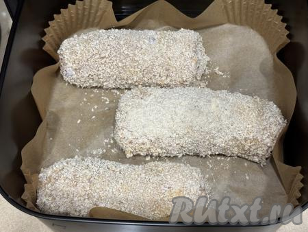 Дно аэрогриля застелить пергаментом, выложить котлеты по-киевски.