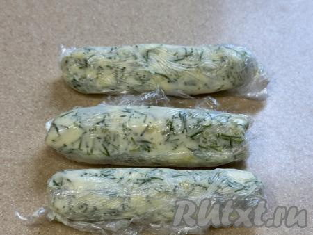 Получившуюся масляно-чесночную массу разделить на три равных части. Из каждой части масляно-чесночной массы слепить колбаску. Каждую колбаску завернуть в пищевую плёнку и убрать в морозилку (ориентировочно минут на 20). Масляно-чесночные колбаски должны подморозиться и хорошо держать форму .