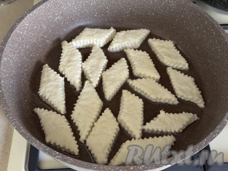 В сковороду влить растительное масло, хорошо его прогреть, затем выложить часть заготовок печенья в один слой.