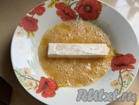 Затем обмакнуть сырные брусочки в яйцо со всех сторон.