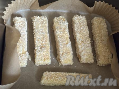 Чашу аэрогриля застелить пергаментом, выложив пергамент на решётку аэрогриля. Аккуратно разложить сырные палочки в панировке в один слой на пергамент. Установить чашу в аэрогриль, выставить температуру 200 градусов, время - 5-7 минут