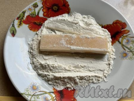 Обвалять сырные брусочки в муке со всех сторон.