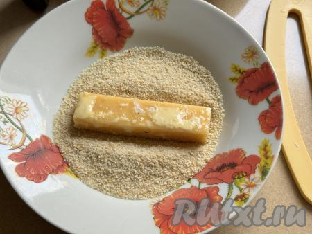 Далее хорошо обвалять сыр в панировочных сухарях со всех сторон.