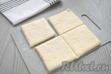 Рабочую поверхность немного присыпаем мукой, выкладываем размороженный пласт слоёного теста, разрезаем его на 4 одинаковых части.