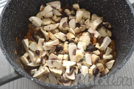 Пока обжариваются овощи с говядиной, моем шампиньоны, нарезаем на средние кусочки. После того как морковка станет мягкой, добавляем к говядине с овощами нарезанные грибы, перемешиваем, обжариваем 7-8 минут, периодически перемешивая.