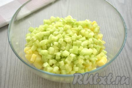 Огурец вымыть, кожуру я предпочитаю срезать. Нарезать огурец на небольшие кубики, добавить в миску с картофелем.