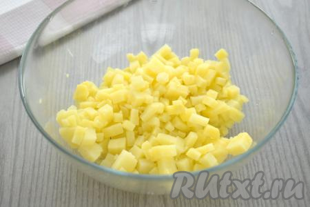 Отварить картошку в кожуре до полной готовности (в течение 25-30 минут с момента закипания воды, готовые клубни будут легко прокалываться вилкой). Яйца отварить в течение 10 минут с момента закипания воды. Варёным яйцам и картофелю дать полностью остыть, очистить непосредственно перед приготовлением окрошки. Нарезать очищенную картошку на небольшие кубики, переложить в глубокую миску.