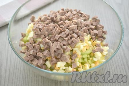 В миску с овощами и яйцами добавить варёный язык, нарезанный на небольшие кубики.