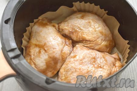 Чашу аэрогриля застилаем пергаментом. Куриные бёдра, замаринованные в соусе "Терияки",&nbsp; выкладываем кожей вверх в чашу аэрогриля. Отправляем чашу в аэрогриль. Включаем аэрогриль на 40 минут, температуру выставляем на 180 градусов. Через 20 минут с начала запекания куриные бёдра переворачиваем и продолжаем запекать оставшиеся 20 минут.