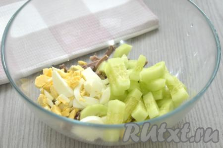 Огурец моем, очищаем от кожуры, нарезаем на небольшие брусочки, выкладываем в миску с яйцами и языком.