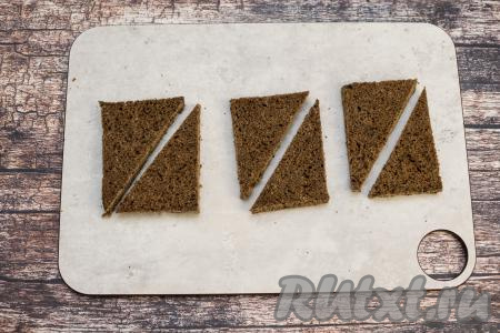 Каждый подготовленный кусочек чёрного хлеба разрезать по диагонали. Я всего взяла 3 ломтика хлеба, из них получается 6 небольших треугольных бутерброда.