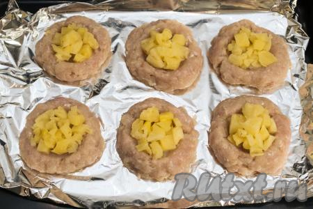 Разложить кусочки ананасов в углубления мясных гнёзд из фарша и отправить в разогретую до 180 градусов духовку на 25 минут.