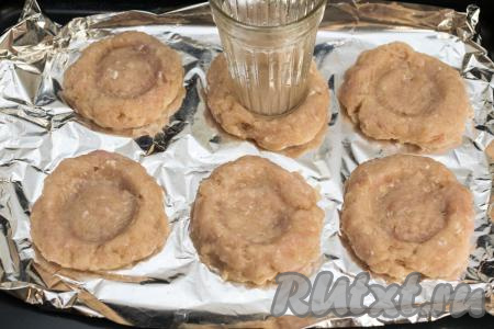 Разделить фарш на 6 равных частей. Периодически смачивая руки водой, каждую часть фарша скатать в шарик. Противень застелить фольгой. На расстоянии друг от друга выложить на противень шарики из фарша, слегка приплюснуть каждый шарик рукой, получится достаточно плоская котлета. При помощи дна обычного стакана сделать в середине каждой котлеты углубление, формируя мясные гнёзда из фарша, как на фото. Если стакан пристаёт к фаршу, тогда смочите его немного водой.