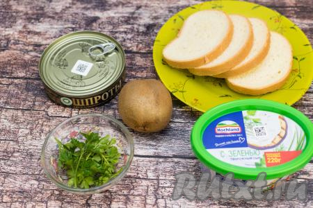 Подготовить продукты для приготовления бутербродов со шпротами и киви. Творожный сыр можно взять как с добавками, так и классический (я&nbsp; я&nbsp;взяла с зеленью). Киви лучше выбирать спелый, но не очень мягкий, чтобы можно было его тонко нарезать. Зелень (у меня - петрушка) промыть водой. Вымытую зелень я сразу раскладываю на бумажном полотенце, чтобы она немного обсохла, пока я делаю бутерброды.