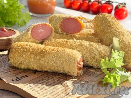 Вкусные, сытные сосиски, покрытые аппетитным кляром, переложить из чаши аэрогриля на тарелку и, дополнив любимым соусом и гарниром, в тёплом виде&nbsp;подать к столу.